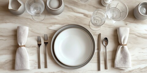 Elegant table setting with white dishes, cutlery, and glassware on a marble surface. Perfect for formal dining and sophisticated meals.