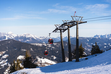 View of red gondolas of cable car and ski slope in Flachau, Austrian Alps, Snow Space Salzburg, part of Ski Amade skiing area
