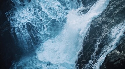 A high angle close up view of a powerful cascading waterfall with intense blue hues and strong textures