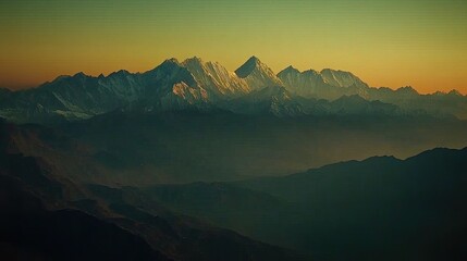 Magnificent mountain range at sunset with soft golden light illuminating the snow capped peaks