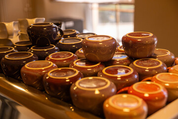 Handmade ceramic mugs drying on a coffee machine lid in a cozy coffee shop