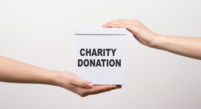 Hands exchanging a charity donation box.