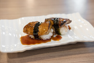 Foie gras sushi with sauce served on plate