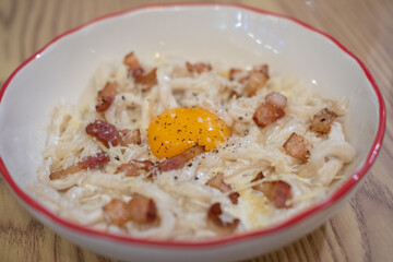 Pici bacon cream carbonara served on plate. Pici is a thick, hand-rolled pasta.
