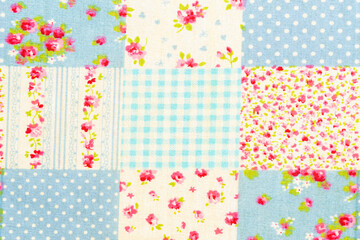 Blue floral fabric background showing a patchwork of various textures and patterns