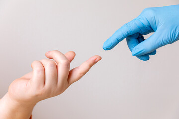 Doctor's hand in a blue medical glove reaching toward female patient's hand offering help isolated...
