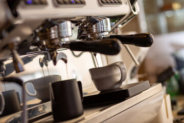 Closeup of pump driven espresso machine and portafilter brewing by forcing pressurized water through puck.