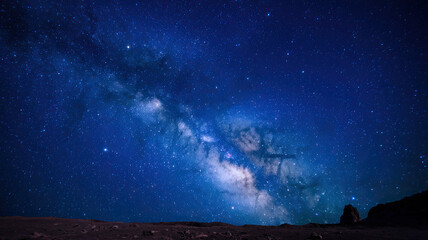 Fototapeta premium Starry Night Sky, Vast Expanses Filled with Twinkling Stars, Deep Dark Blue Backdrop, Celestial Wonders Visible, Peaceful and Majestic Atmosphere of the Night Sky