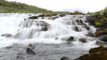 long exposure of fast flowing water cascading down rocks in a mountain river