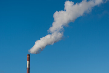 Greenhouse gas emissions into the atmosphere. Smoking power plant chimney, carbon dioxide released...