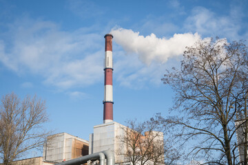 Obraz premium Greenhouse gas emissions into the atmosphere. Smoking power plant chimney, carbon dioxide released into the atmosphere. 