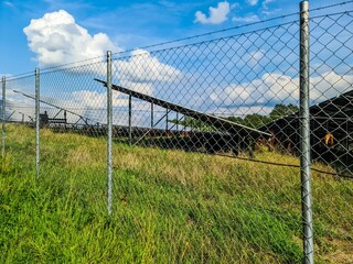 Wire mesh fence protecting solar panels in a field