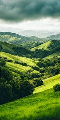 Obraz premium Lush green rolling hills and dramatic cloudy sky landscape with vibrant scenery and serene ambiance