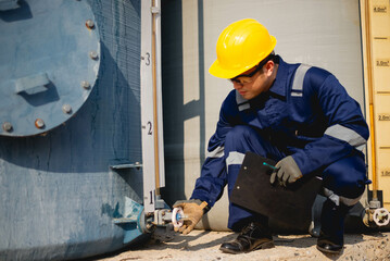 A plumbing inspector is hard at work inspecting the operation of a high-pressure water pump in an industrial plant.