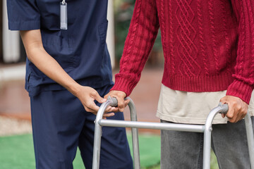 Healthcare professional assisting elderly man with walker, supporting mobility and wellbeing
