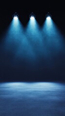 A dark stage lit by three spotlights against a smoky dark blue background, creating a mysterious and moody atmosphere.
