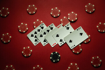 On the red table in the club there are chips and playing cards with a lucky combination of high...