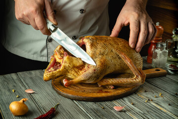 A talented chef tries to cut a raw duck carcass, demonstrating his culinary skills. The atmosphere is warm and welcoming, and the ingredients nearby hint at delicious food
