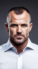 Obraz premium Portrait of a handsome young man in a white shirt with a serious expression, set against a dark background, showcasing detailed textures and lighting.
