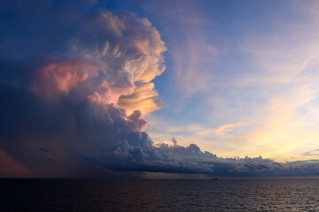 View from cargo ship at sea to dramatic clouds and colorful sunset ahead