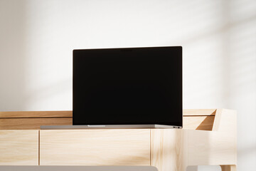 Opened laptop with blank black screen on the wooden desk