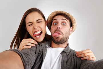 Couple, selfie and studio portrait for social media, funny faces and memory of love on white background. People, together and online for relationship update, profile picture and internet photography
