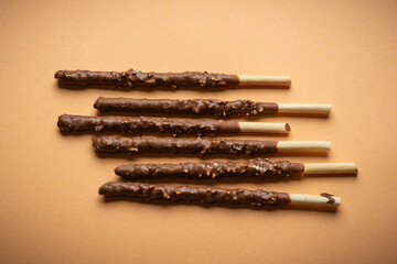 Chocolate Coated Snack Sticks with Nuts on Brown