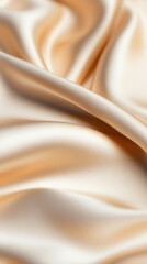 A close-up view of beige silk fabric smoothly draped and floating against a white background, creating a flowing and elegant appearance.