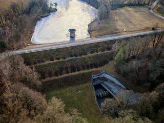 Aerial panorama of frozen dam reservoir covered with snow during winter season.
