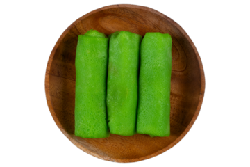 Indonesian dadar gulung on rustic round wooden plate isolated background