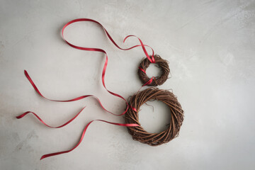 Overhead view of two vine wreathes with red ribbons in the shape of the number 8 
