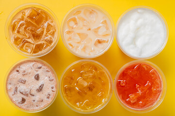 Takeaway glasses of summer drinks with ice. Lemonades and coctails top view