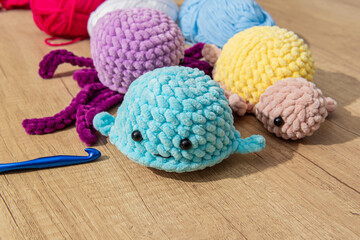 Crocheted stuffed animals on wooden table. Crocheted sea dwellers