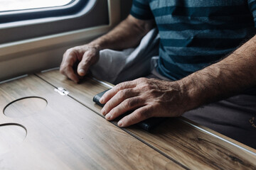 Close-up of strong, large hands of a man resting on a wooden table