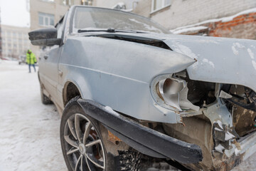 Damaged front of a blue-gray sedan car after an accident