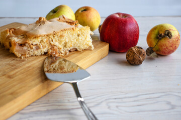 Piece of traditional thanksgiving apple cinnamon pie on the wooden cutting board on the white...
