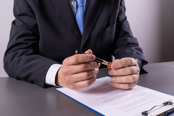 Business executive removing pen cap while preparing to sign document, office work concept