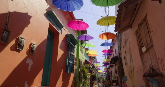 Walking in street with umbrellas in Getsemani,  Cartagena. 