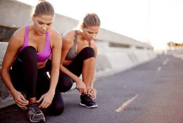 Women, fitness and tying with shoes in city for workout preparation, exercise or outdoor training. Active, female people or friends getting ready with tie laces for running, cardio or sprint in town