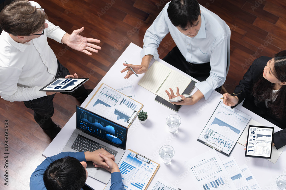 Fototapete Top view analyst team utilizing BI Fintech to analyze financial data at table in meeting room. Analytic BI dashboard power on paper for business insight and strategic marketing planning. Prudent
