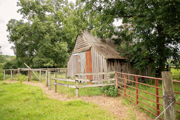 Weathered wooden barn with rustic fencing in a peaceful rural setting