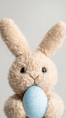 Fototapeta premium Adorable bunny plush toy with speckled easter egg for holiday gift inspiration