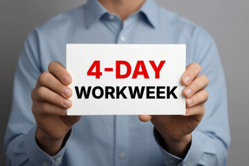 4 DAY WORK WEEK text words phrase on a sign in the hands of a worker