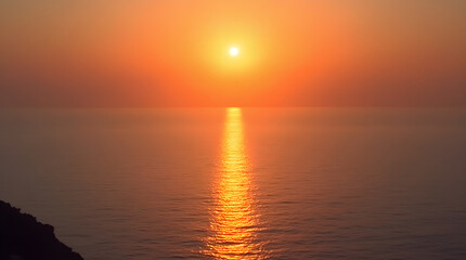 Obraz premium Stunning Sunset Over Ocean: Vibrant Orange Hues and Glowing Sun Reflection on Calm Water