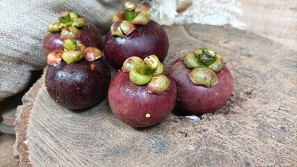 Fresh mangosteen fruit arranged on a wooden table