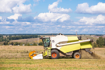 Agricultural industry. A combine harvester harvests from the field. The concept of processing and collection . Rural landscape. Agricultural machinery.