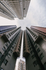 Looking up perspective of densely packed residential buildings in Hong Kong, China.  Architecture, urban living, and high-density housing.