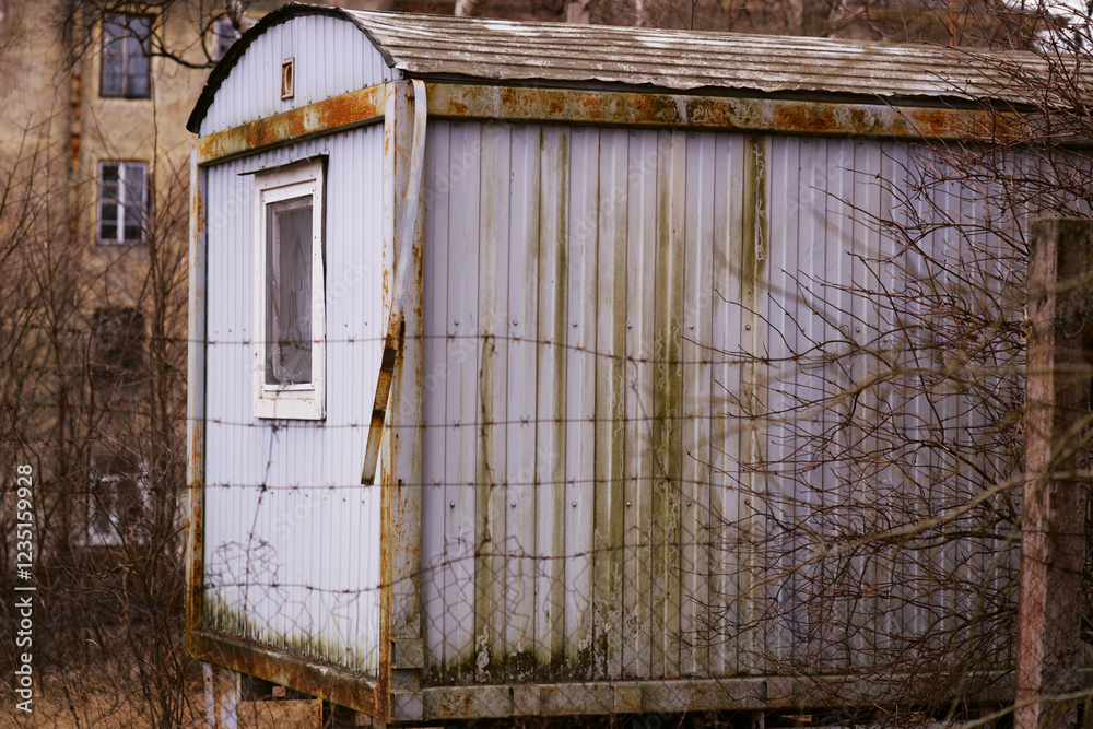 Poster a small white building with a broken window, suitable for use in historical or abandoned place scene