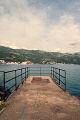 Weathered and abandoned wooden dock stretching into the calm waters of Bečići, Montenegro. A symbol of time's passage and the quiet beauty of decay.
