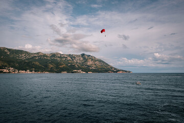 Scenic view of the Becici coastline in Montenegro.  Turquoise waters of the Adriatic Sea meet the sandy beach, with mountains in the background.  Summer vacation destination.